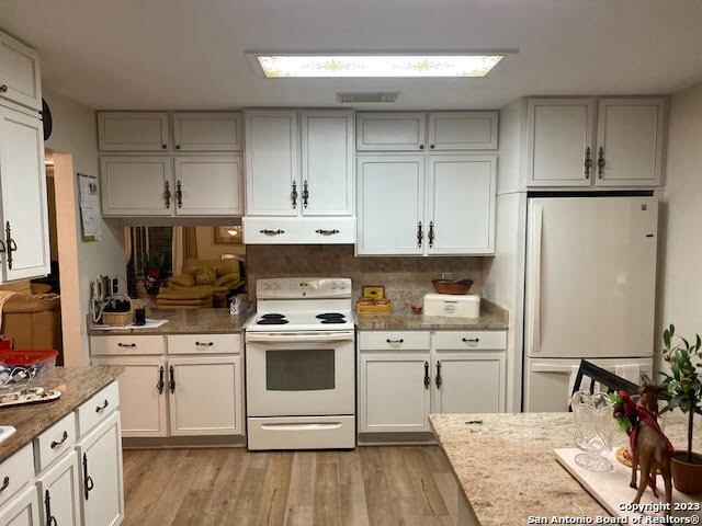 kitchen featuring white appliances, white cabinets, and light hardwood / wood-style flooring