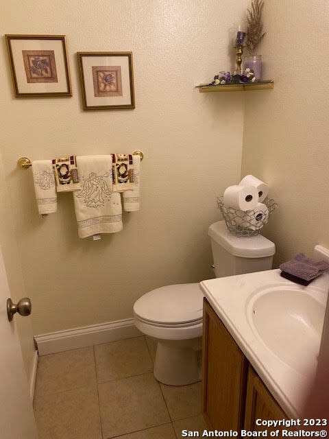 bathroom featuring tile patterned flooring, vanity, and toilet