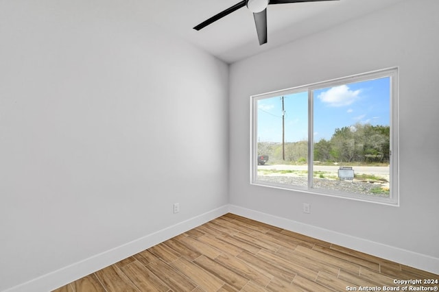 empty room with ceiling fan and light hardwood / wood-style flooring