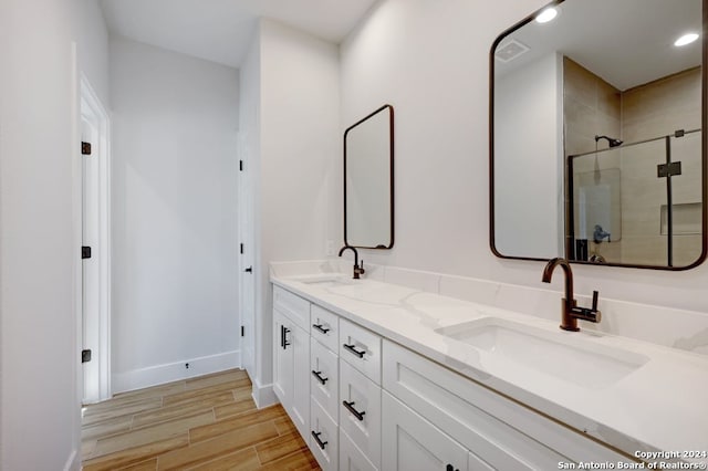 bathroom with walk in shower, dual sinks, and oversized vanity