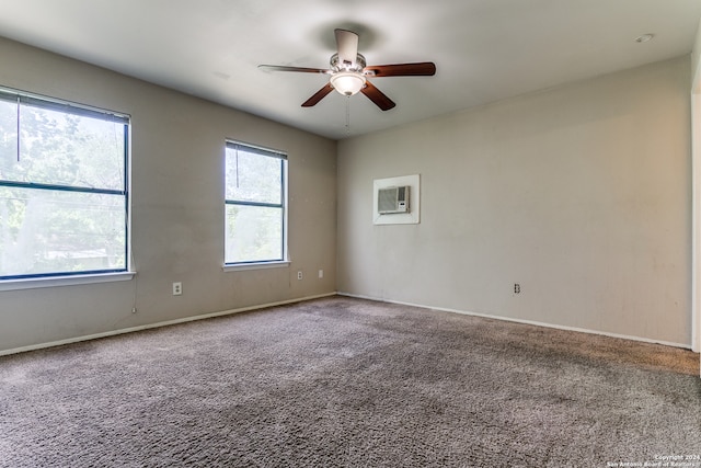 spare room featuring carpet flooring, ceiling fan, and a wall unit AC