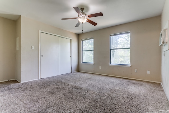 unfurnished bedroom featuring a closet, ceiling fan, and light colored carpet