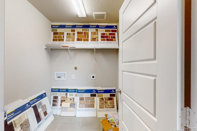 laundry area featuring electric dryer hookup, a textured ceiling, and hookup for a washing machine