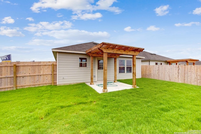 back of property with a patio area, a yard, and a pergola