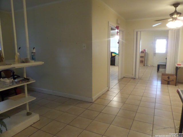 hallway featuring ornamental molding and light tile floors