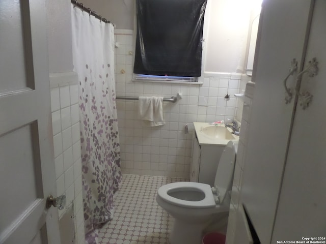 bathroom with tile walls, toilet, tile floors, and vanity