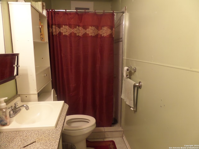 bathroom with tile flooring, toilet, and large vanity