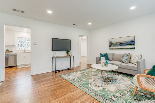 living room with sink and light wood-type flooring