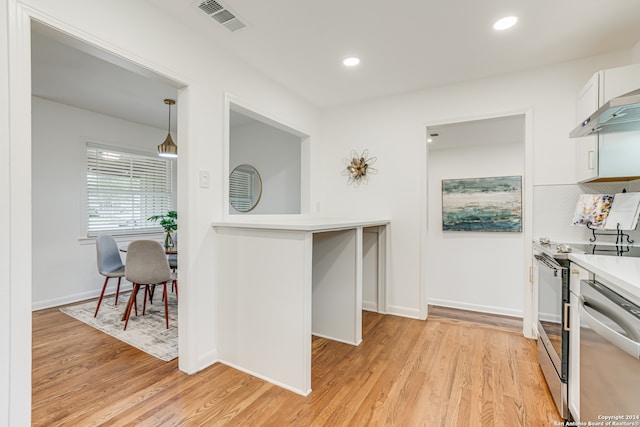 kitchen featuring stainless steel dishwasher, decorative light fixtures, light hardwood / wood-style flooring, white cabinets, and electric range oven