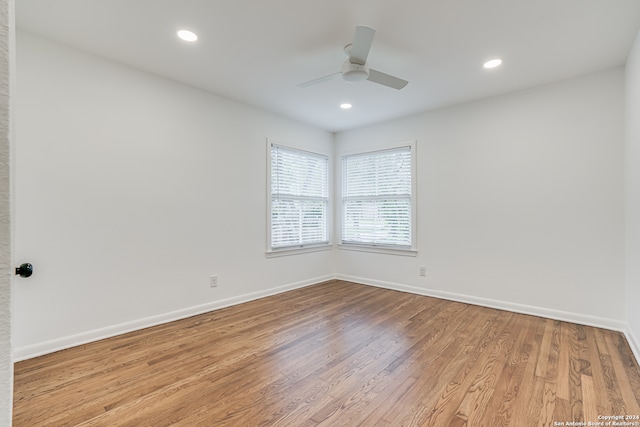 empty room with ceiling fan and light hardwood / wood-style flooring