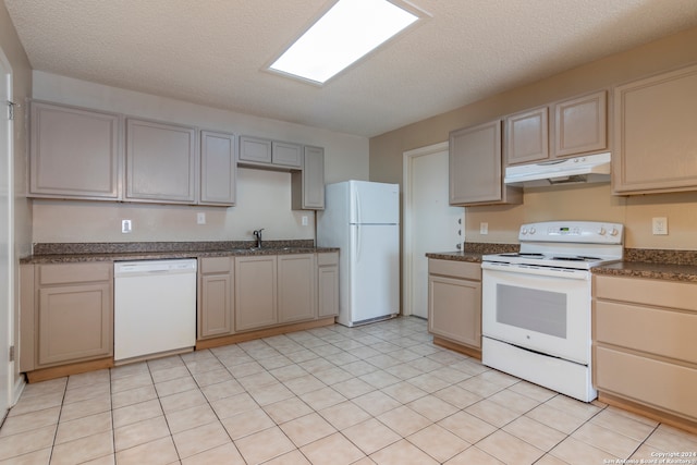 kitchen featuring white appliances, a textured ceiling, and light tile floors