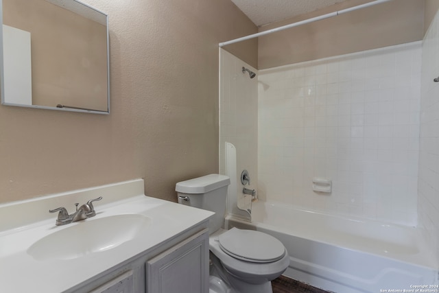 full bathroom featuring a textured ceiling, vanity, toilet, and tiled shower / bath