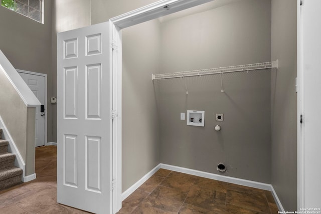 washroom featuring washer hookup, hookup for an electric dryer, and dark tile flooring