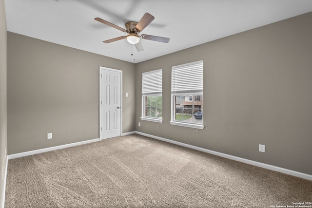 carpeted empty room featuring ceiling fan