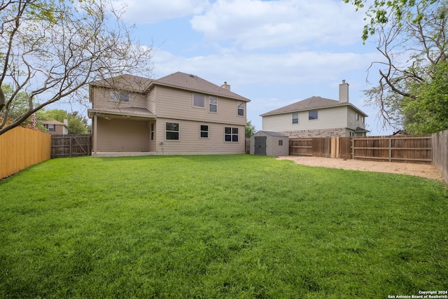 back of property featuring a storage unit and a lawn