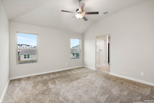 unfurnished room with light colored carpet, ceiling fan, a wealth of natural light, and lofted ceiling