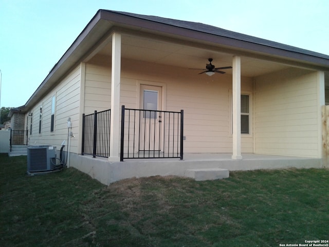 back of house with a yard, central air condition unit, and ceiling fan