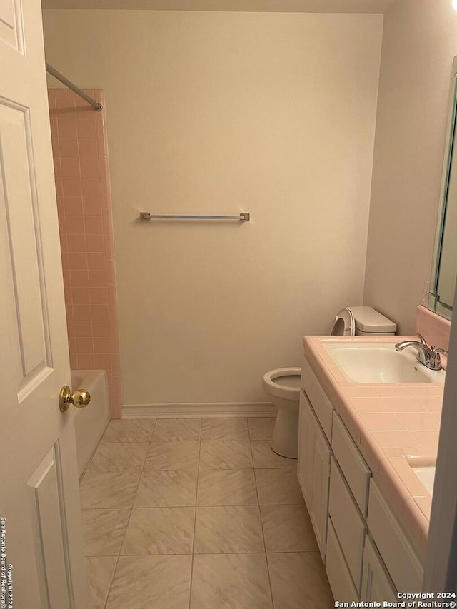 full bathroom featuring toilet, dual bowl vanity, tile floors, and tiled shower / bath combo