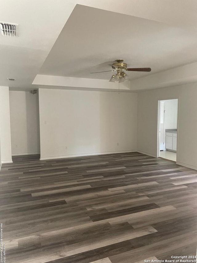 empty room featuring ceiling fan and dark hardwood / wood-style flooring