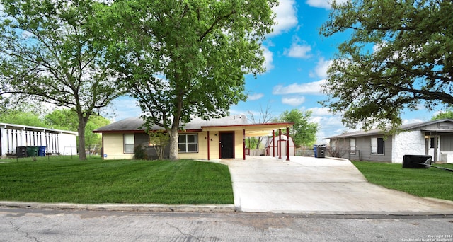 view of front of home with a front yard and a carport