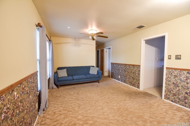 living area featuring light colored carpet and ceiling fan