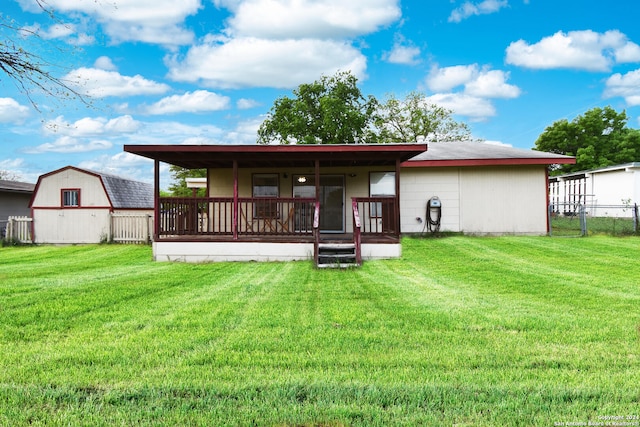 back of property featuring an outdoor structure and a lawn