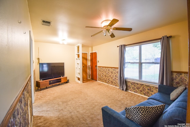 carpeted living room with ceiling fan