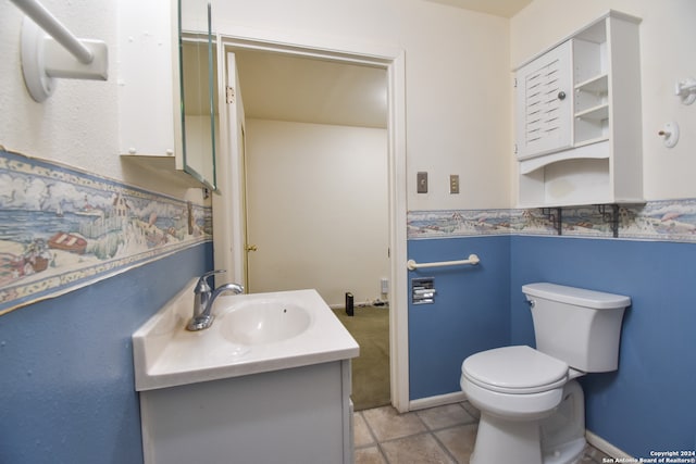 bathroom with tile flooring, large vanity, and toilet