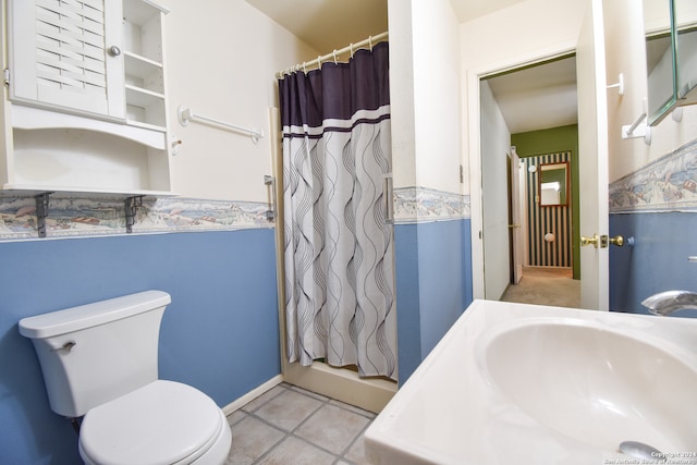 bathroom with toilet, tile floors, and sink