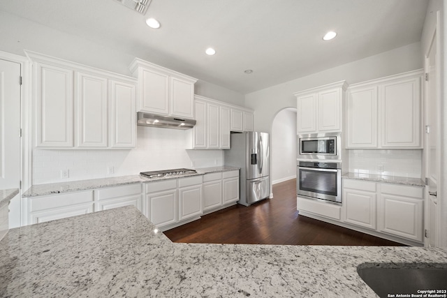 kitchen with backsplash, stainless steel appliances, white cabinets, and dark hardwood / wood-style flooring