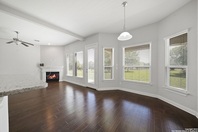 unfurnished living room with dark hardwood / wood-style floors, ceiling fan, and beamed ceiling