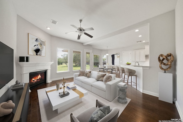 living room featuring ceiling fan, sink, and hardwood / wood-style floors