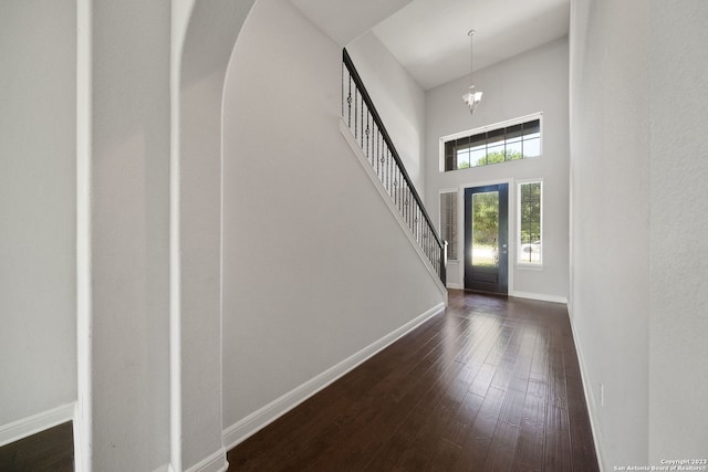 foyer featuring dark hardwood / wood-style flooring, a chandelier, and a high ceiling