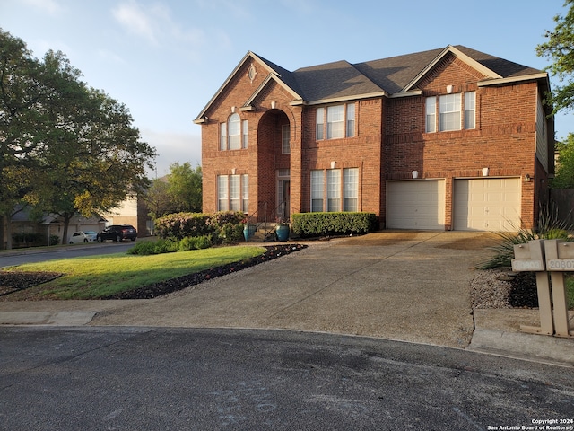 view of front of house featuring driveway, brick siding, a front lawn, and an attached garage