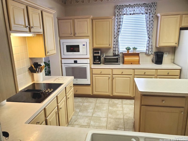 kitchen featuring white appliances, light countertops, and light brown cabinetry