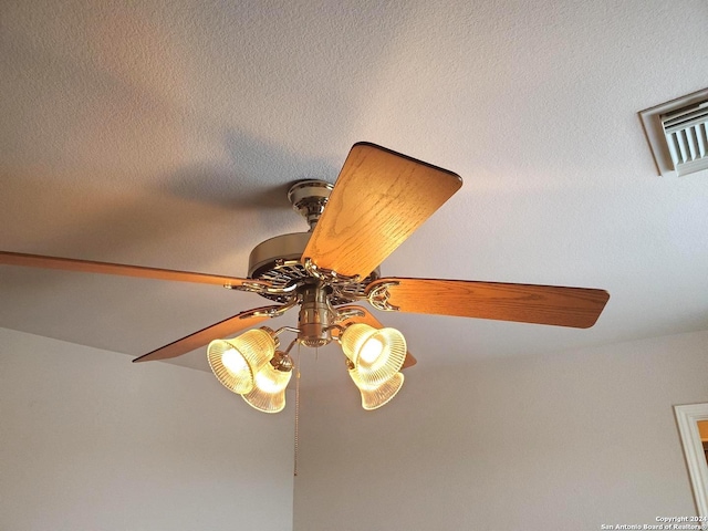 interior details featuring ceiling fan and a textured ceiling