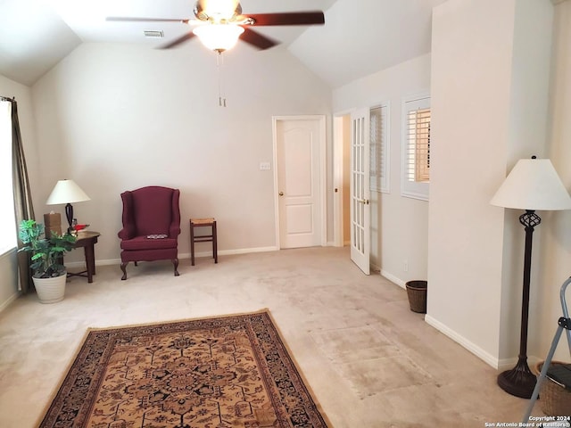 living area with light carpet, ceiling fan, and vaulted ceiling