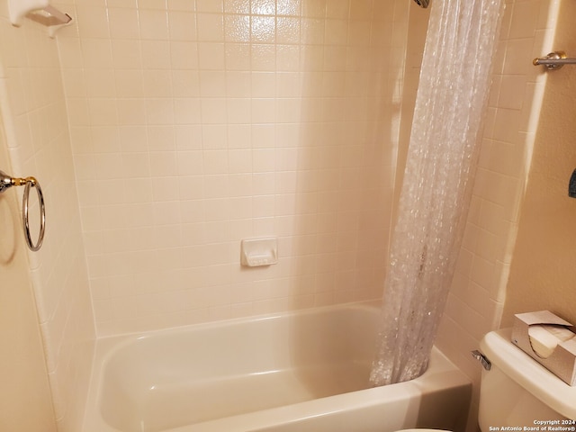 full bath featuring toilet and shower / bath combo with shower curtain