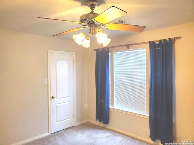 carpeted empty room featuring ceiling fan