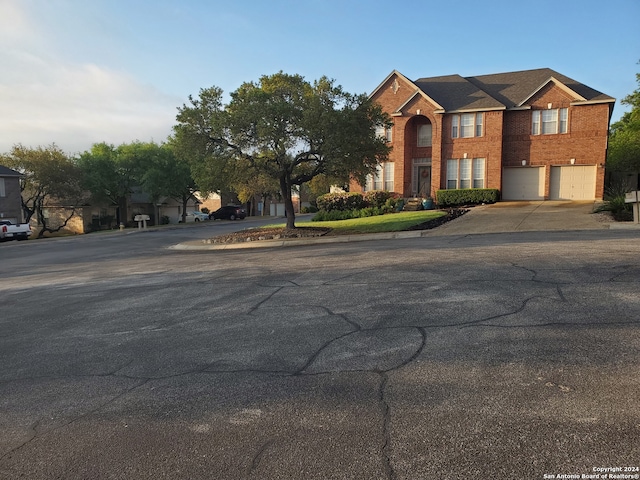 view of front facade with driveway and brick siding