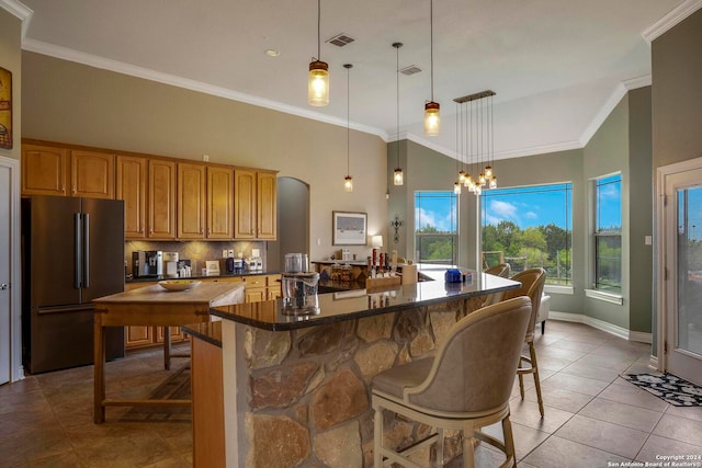 kitchen with pendant lighting, black refrigerator, a center island, and a breakfast bar