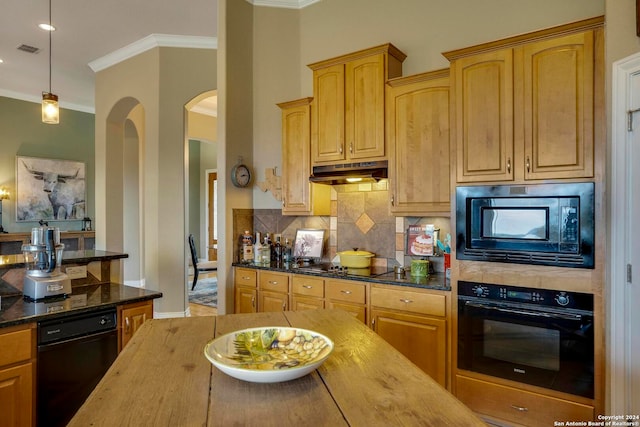 kitchen featuring decorative light fixtures, hardwood / wood-style flooring, dark stone counters, black appliances, and backsplash