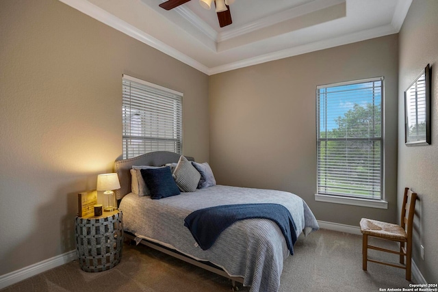 carpeted bedroom featuring a raised ceiling, ceiling fan, and crown molding