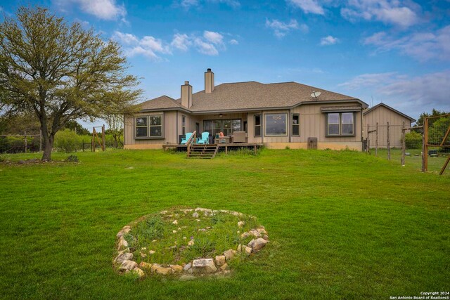 back of house featuring a deck and a yard