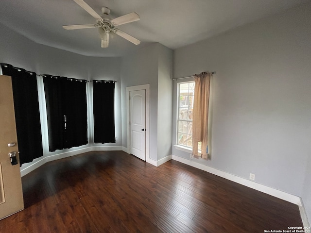 empty room with ceiling fan and dark hardwood / wood-style flooring