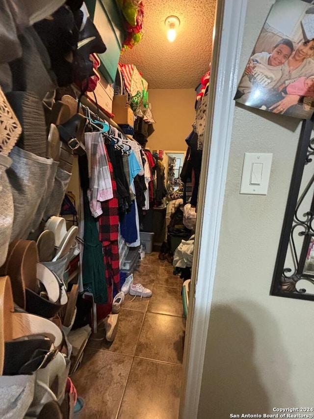 walk in closet featuring dark tile floors