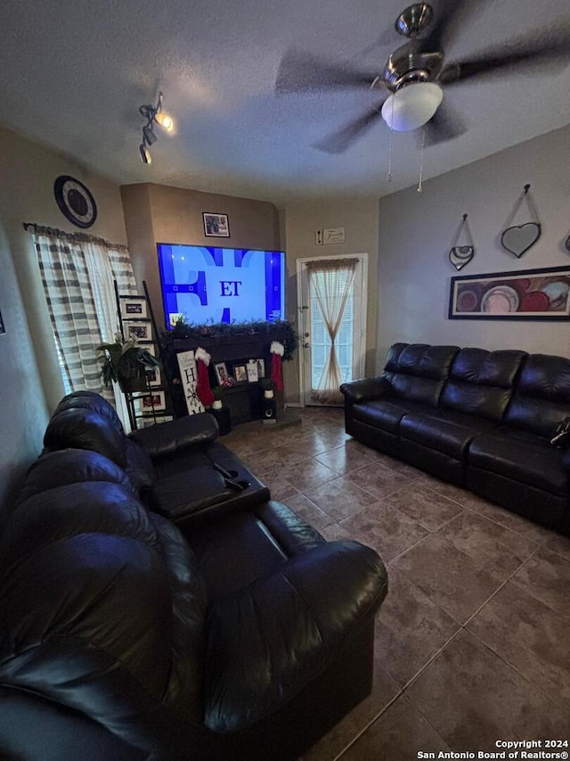 living room featuring dark tile floors, ceiling fan, a textured ceiling, and rail lighting