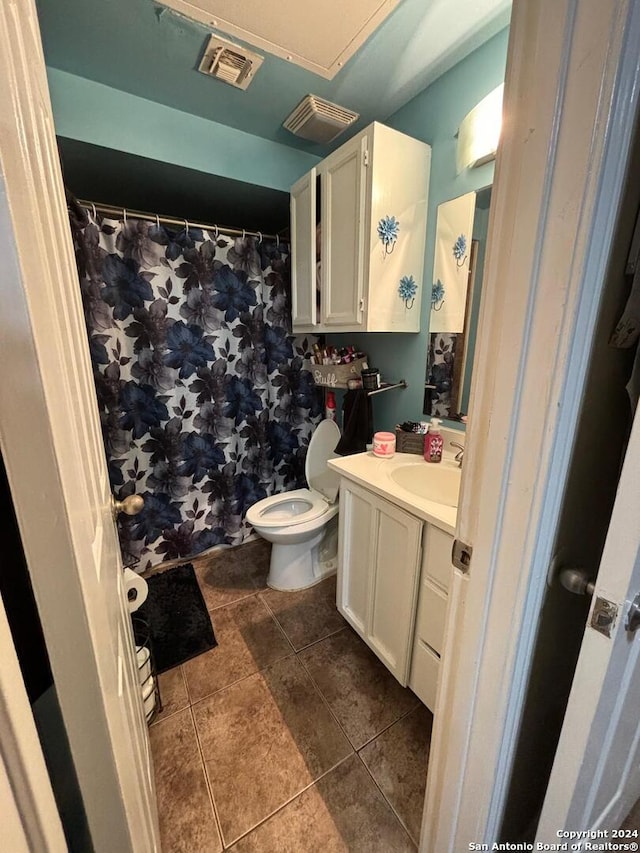 bathroom featuring tile floors, large vanity, and toilet