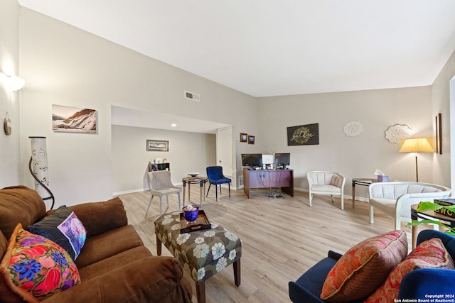 living room featuring light hardwood / wood-style flooring and vaulted ceiling