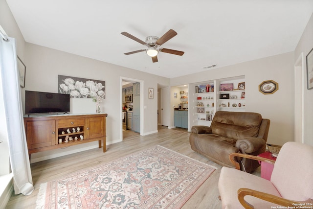 living room featuring ceiling fan and light hardwood / wood-style flooring